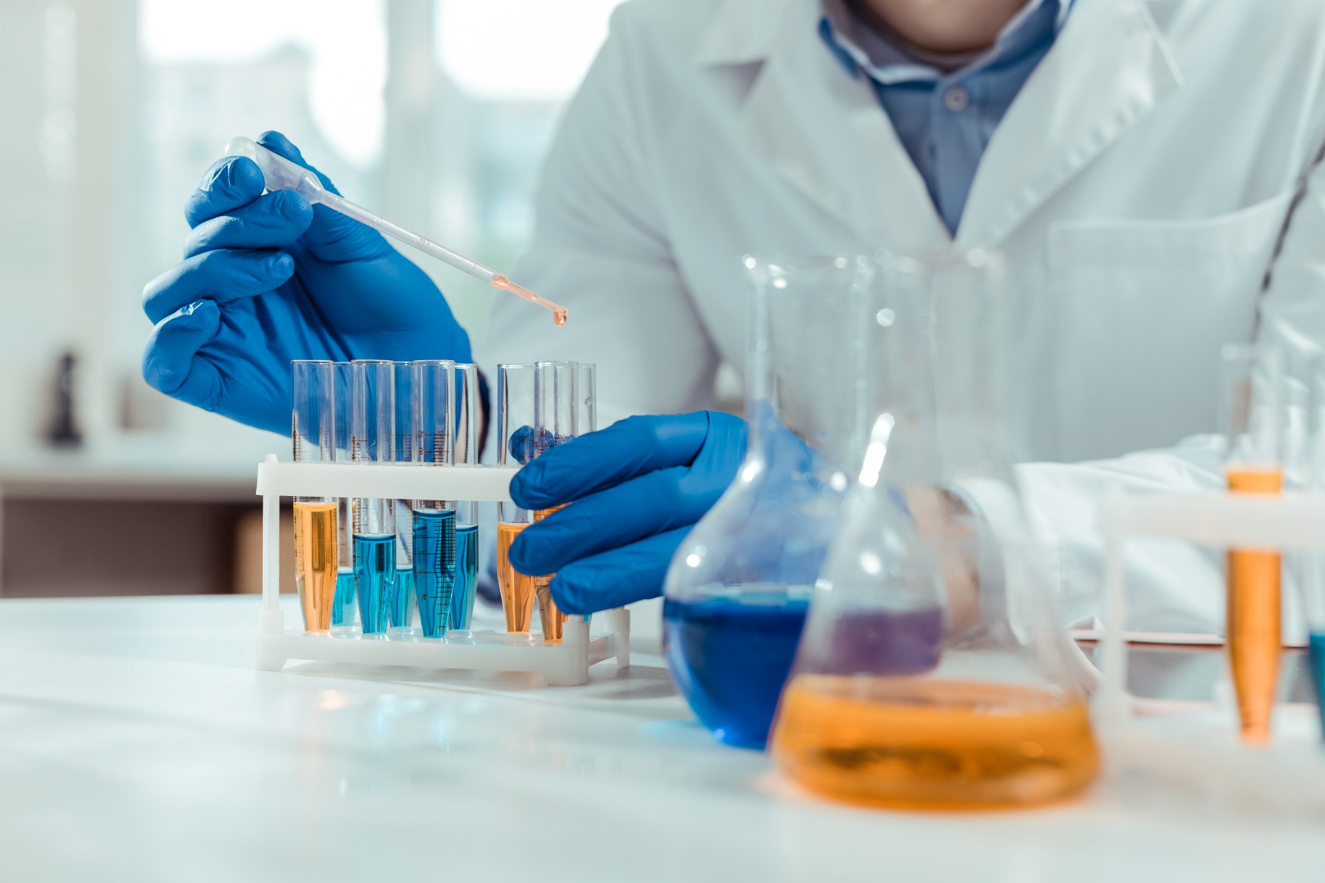 A worker transfers liquid to a test tube