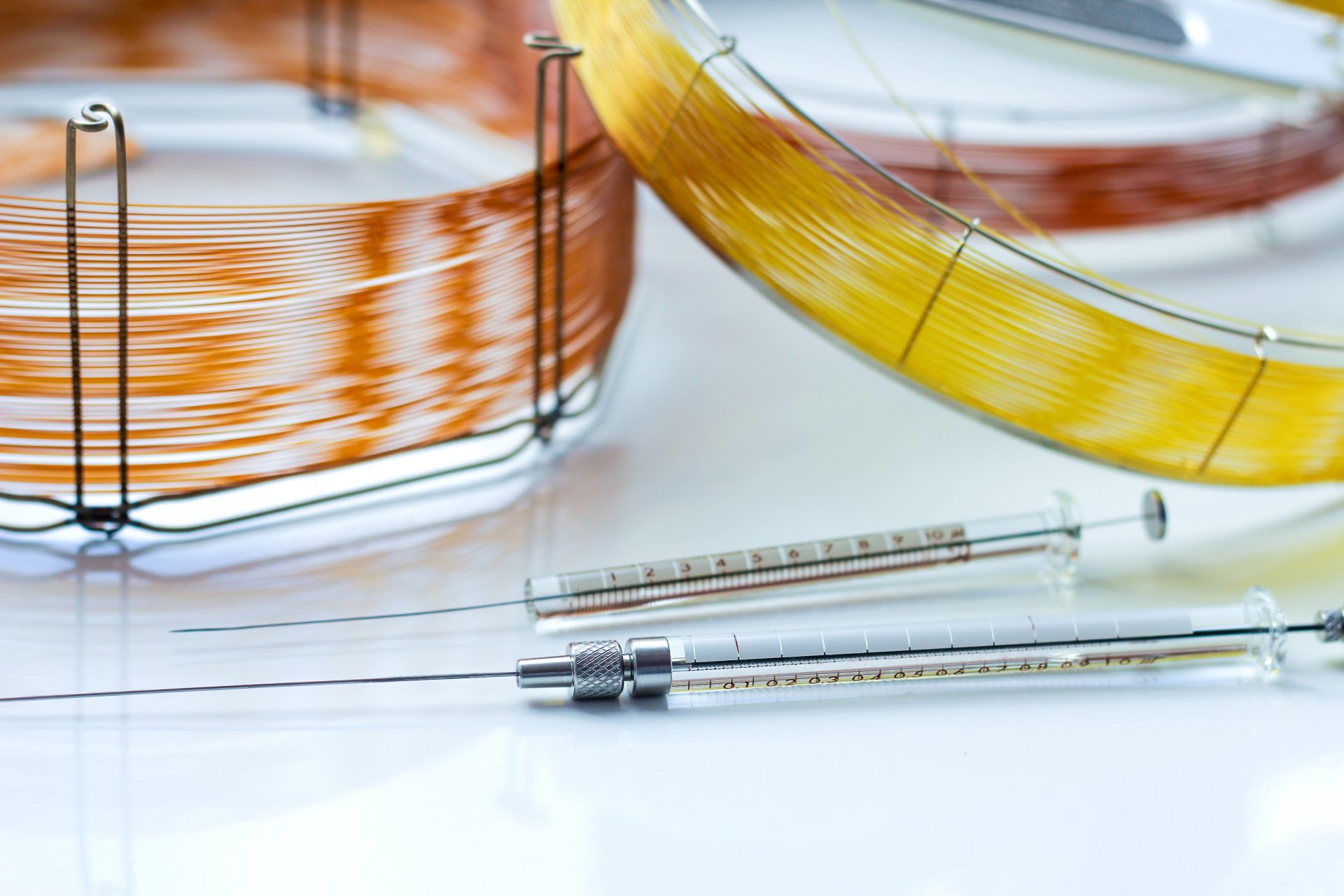 Capillary columns of different lengths for gas chromatographic analysis and glass syringes for sample insertion.