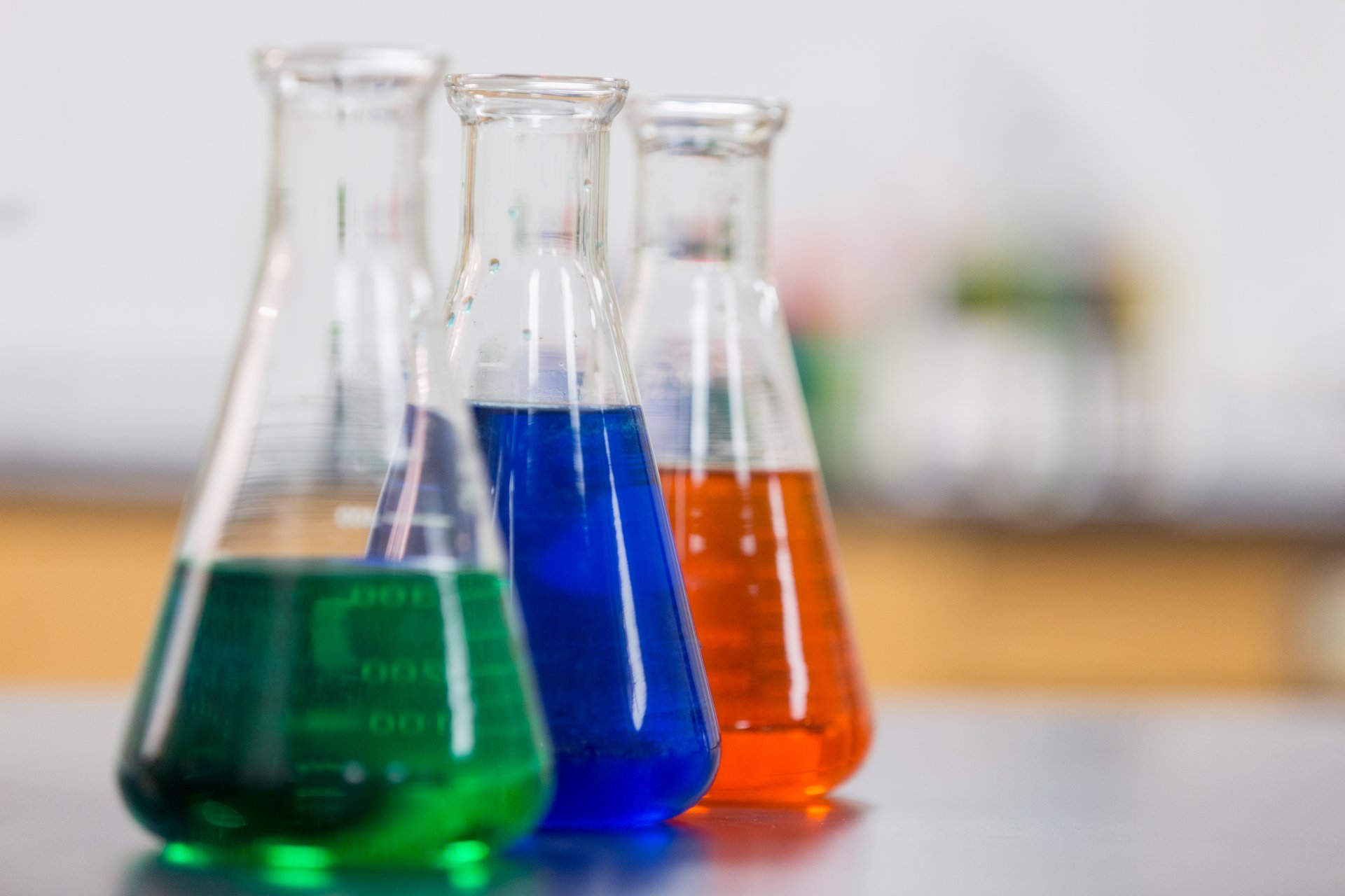 3 erlenmeyer flasks filled with colored liquid